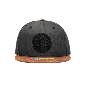 Front view of the Borussia Dortmund Orion Snapback with high structured crown, flat peak suede-like brim, and snapback closure, in Black/Brown.